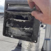 Exterior vent needs replacing due to damage, dry rot, and warping.